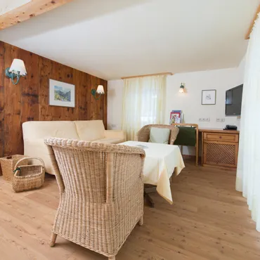 Zwölferkopf Cozy alpine-style living room with wicker furniture and wooden wall panels
